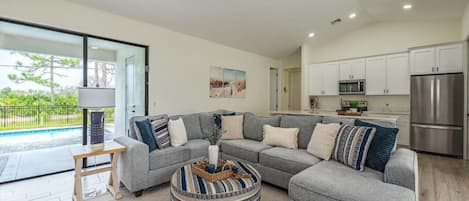 Living room with open views to an immaculate private pool and manicured yard