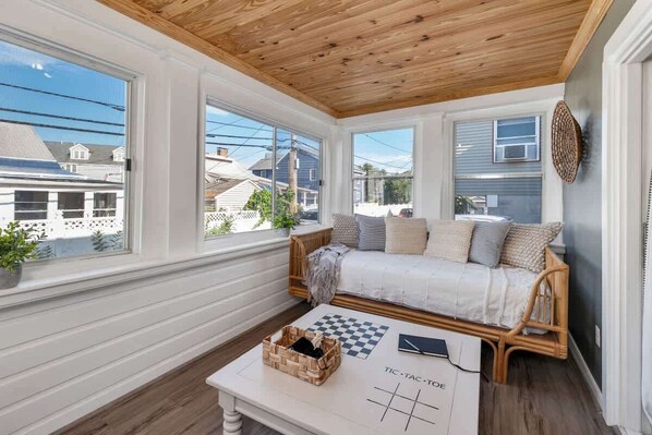 Three season sun porch with a couch/bed...i love this room!