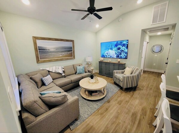 Large open living room with a 75 inch Smart TV.