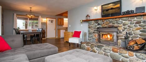 L shaped couch with river rock hearth surrounding a cozy wood stove