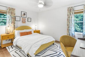 Cozy and bright bedroom with stylish decor, large windows, and a comfortable bed for a restful night’s sleep.