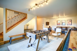 Downstairs game room with foosball, shuffleboard tables and board games.
