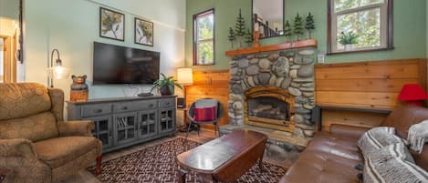 Open Living Room with Vaulted Ceilings, Gas Fireplace & Large SmartTV.