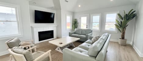 Family room with plenty of seating and a 65" ROKU tv over an electric fireplace