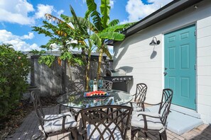 Back, open patio off the kitchen or screened lanai with dining table & BBQ grill