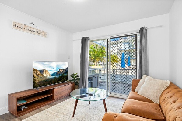 Simple and stylish living room with a modern rustic couch and a smart TV with built-in apps for your entertainment.
