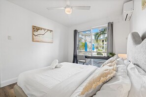The bedroom features air conditioning, a ceiling fan, and a sliding door with a fly screen—giving you comfort and ventilation options to suit your preference.