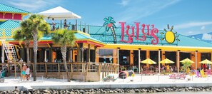 Vibrant beachfront restaurant with colorful decor, outdoor seating, and ocean views.