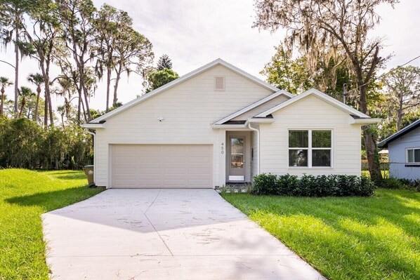 HOME EXTERIOR: Welcome to your tranquil getaway in Mt. Dora! Our front home exterior, with a paved driveway, offers a serene arrival. Lush greenery and trees surround the property, creating a picturesque and peaceful ambiance. Discover the natural beauty of your surroundings from the moment you arrive.