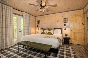 Rest peacefully in the primary suite boasting a king-sized bed, en-suite bathroom, and private balcony with serene forest views. - The Smokey - Sevierville, TN