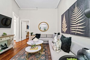 Stylish living room with white walls, a TV, a comfortable sofa, and beautiful decor.
