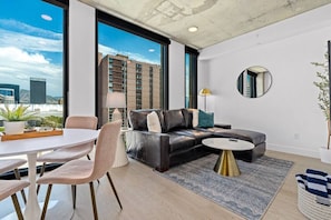 Beautifully designed living room. 65" TV, leather sofa and amazing views of mountains and city skyline.