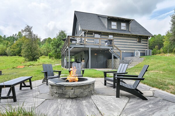 Stone patio with fire pit out the back door. Bear Creek visible from the patio.