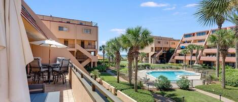 Balcony overlooks the lovely landscaping and pool with a large tanning deck.