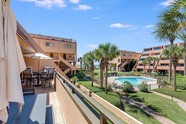 Balcony overlooks the lovely landscaping and pool with a large tanning deck.