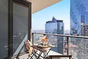 A balcony with a setting & city views.