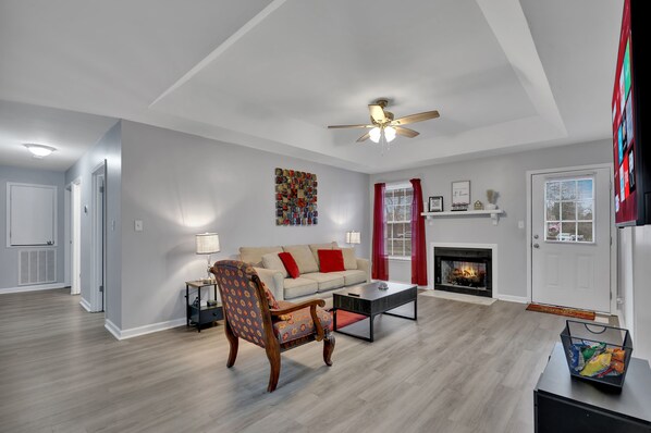 [Living Room] 65" smart tv with Netflix with the chest below that holds two pillows for the sleeper sofa.