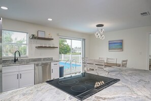 Kitchen & Dining table w/ a view of the pool