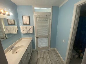 Hallway from Bedroom to Living Room. Sink to the Left and Bathroom to the Right.
