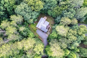 The house is surrounded by an abundance of trees, creating a relaxing ambiance.