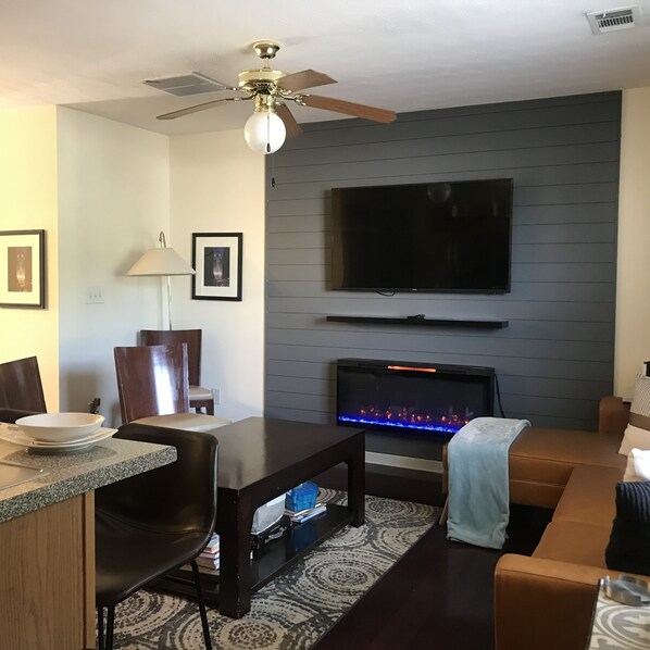 Living room with smart TV, fireplace, and sofa bed