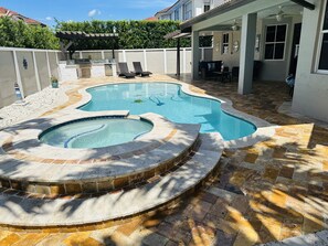 Backyard pool, jacuzzi sitting and dining area. Lounge chairs.