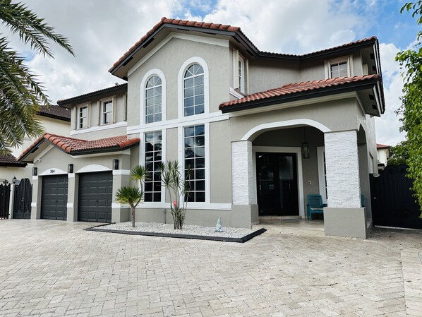 Front of house large driveway, two garages.