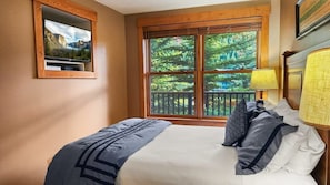 The inviting bedroom is filled with natural light from the large window that looks out towards the mountains so you can wake up and start your day with mountain views!