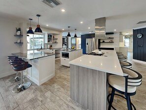 Fully Equipped Kitchen with Stainless Steel Appliances and Breakfast Bar Seating