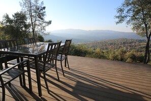 A large deck with an awesome view. Two tables, complete with 10 deck chairs.