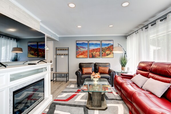 Bright living room with big windows, fire place, smart TV, door to the backyard