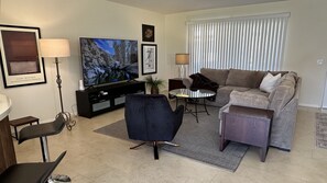 Cozy living room with comfy sectional sofa and new 75-inch smart TV.