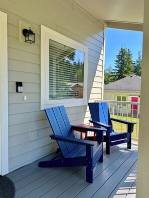South facing covered porch with two Adirondack chairs