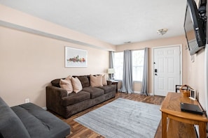 A warm and inviting living area furnished with a cozy and comfortable sofa and a TV.