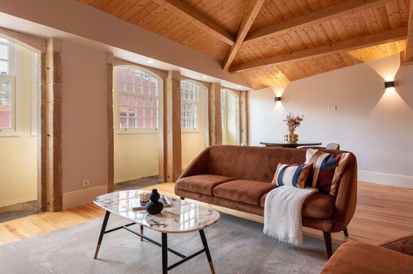Our living area is bathed in natural light thanks to its expansive windows that offer stunning views of the iconic streets of Porto,