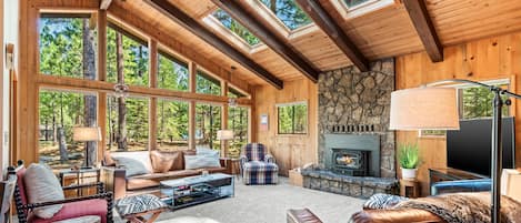 Let the sunshine in! Open living area with plenty of seating, real wood fireplace and TV.