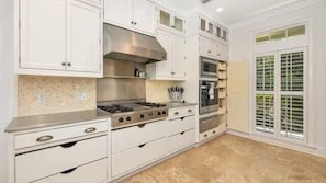 Chef's style kitchen with a gas cook top, oven and a warming drawer