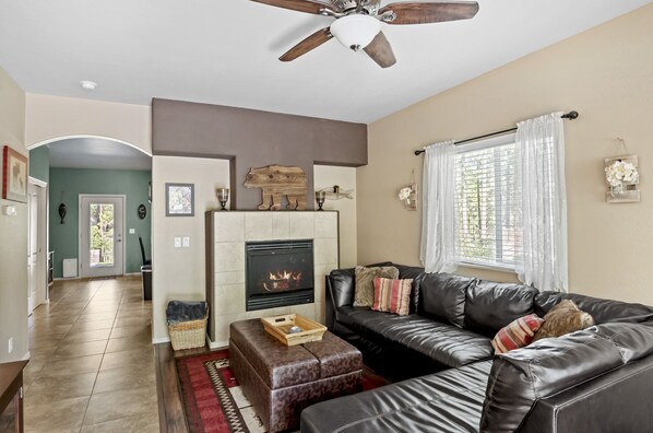 Relax in this inviting living room perfect for unwinding by the fire, with easy access to the backdoor.