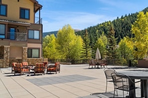A renovated shared outdoor space featuring patio furniture and BBQs provides a great space to enjoy the fresh mountain air with your group.