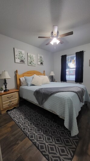 Queen bed with 2 nightstands, lamps and a charging station.