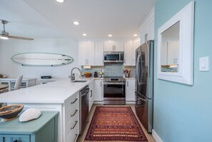 The fully renovated kitchen boasts quartz countertops & all new appliances.