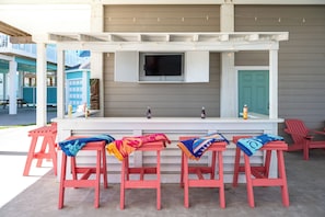 Under-house entertainment area with bar, TV, dining, and ping pong table