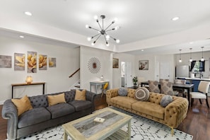 Adjacent to the living area, an open-concept layout seamlessly transitions into the dining space, where a carefully appointed dining table beckons for shared meals and gatherings.