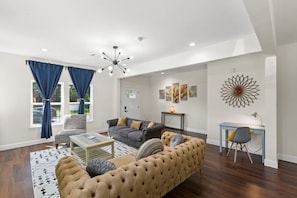 A centerpiece sofa, upholstered in a luxurious fabric that's as soft to the touch as it is pleasing to the eye, commands attention with its contemporary design and plush cushions.
