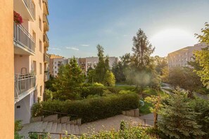 A view from the apartment showcasing a well-kept courtyard garden with trees and greenery.
