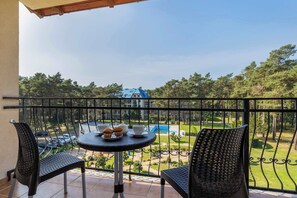 Furnished balcony with green surroundings. 
