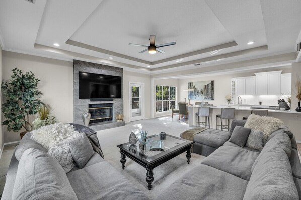 80" TV with Sound Bar/Sub Gas Fireplace Sectional Sofa Open to kitchen Coffee Table Ceiling Fan Alexa Access to back patio/yard