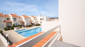 View of the pool and surrounding houses from the upper terrace