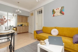 A full view of the combined living and dining area, showcasing the yellow sofa, dining table, and minimalist decor.