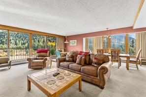 Spacious living area with open floor plan, wood-burning fireplace, and flatscreen TV.